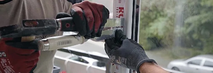 Zwei Personen montieren eine Tür mit einem Schraubenzieher.